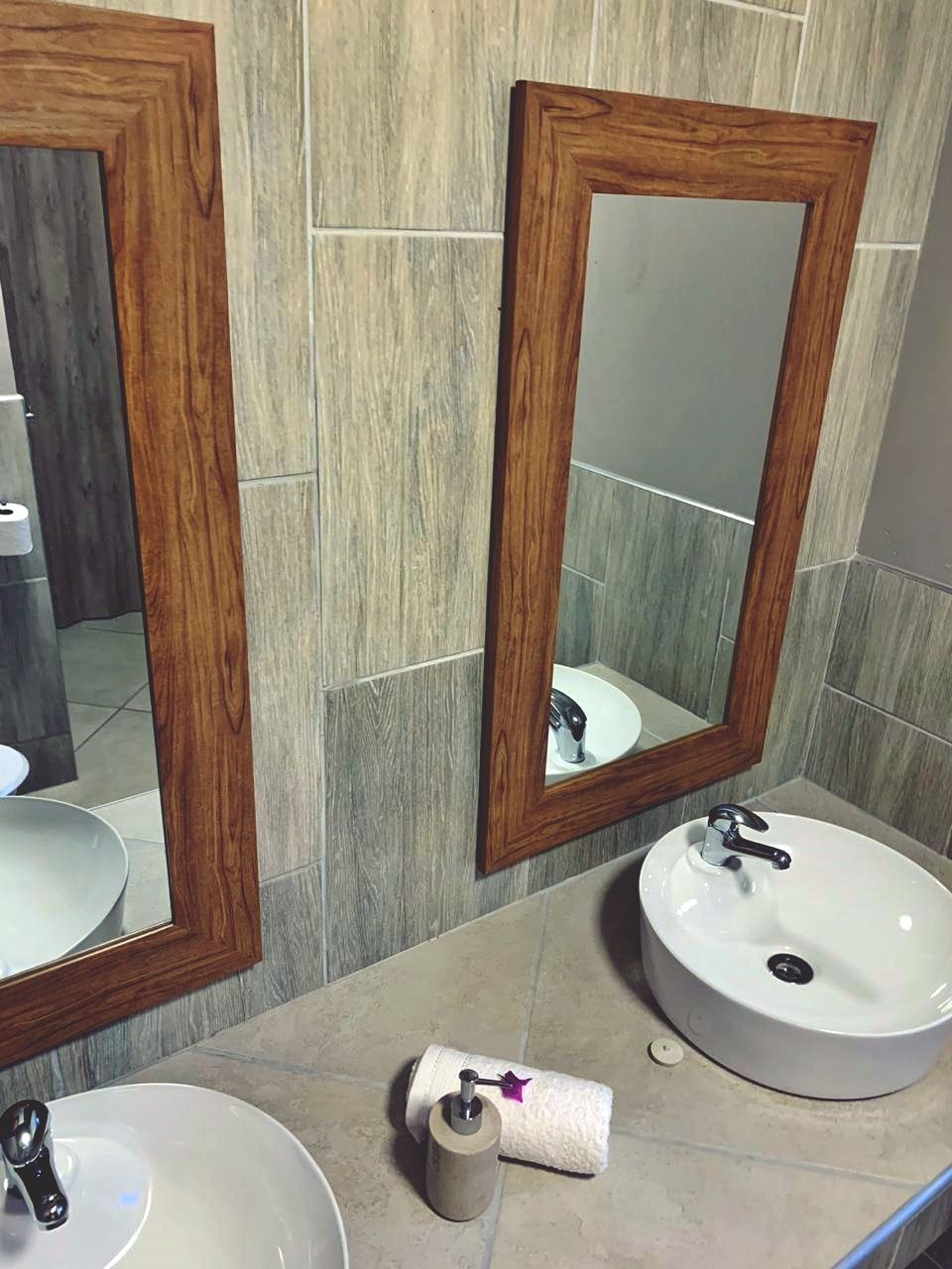 A bathroom with two sinks, a mirror, and a toilet.
