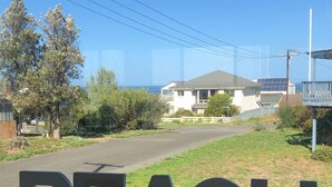 A view of a residential area with a house and a sign that reads "BEACH".