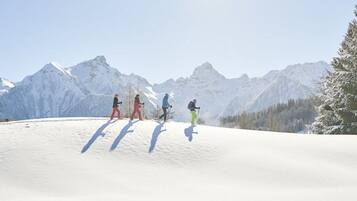 A snowy mountain landscape with skiers.
