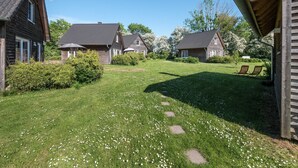 A residential area with multiple houses, a grassy lawn, and a clear sky. - House 2 - SCHMIDT'S Cottages in the countryside (Lüdershagen)