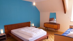 Une chambre à coucher avec un lit en bois, une table de chevet, une commode et un miroir.