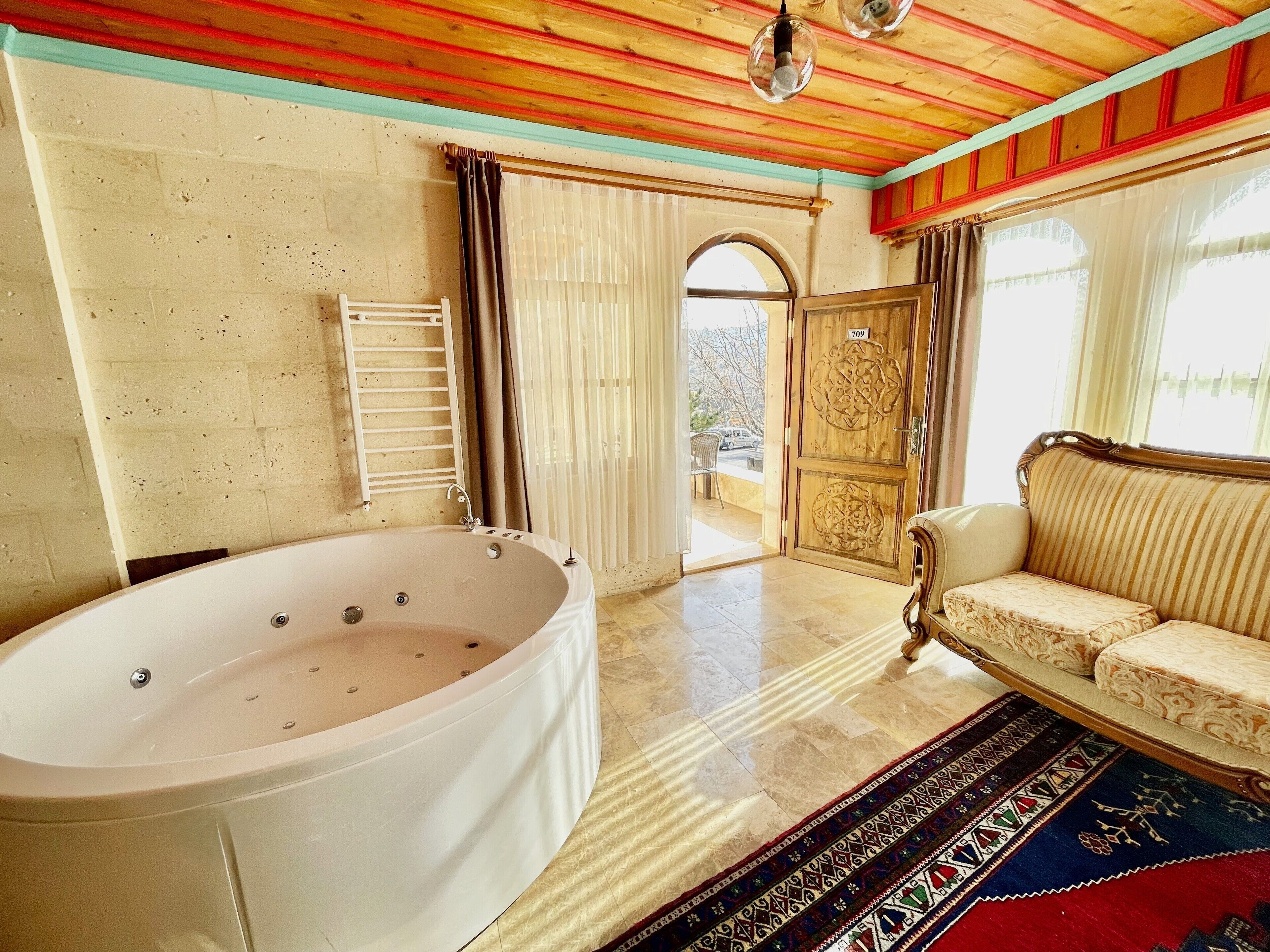 Una habitación con una bañera grande, un sofá y un tapete estampado.