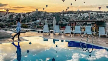 Una piscina al aire libre de temporada, sombrillas