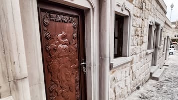 A historic building with a detailed wooden door, stone walls, and a cobblestone street.