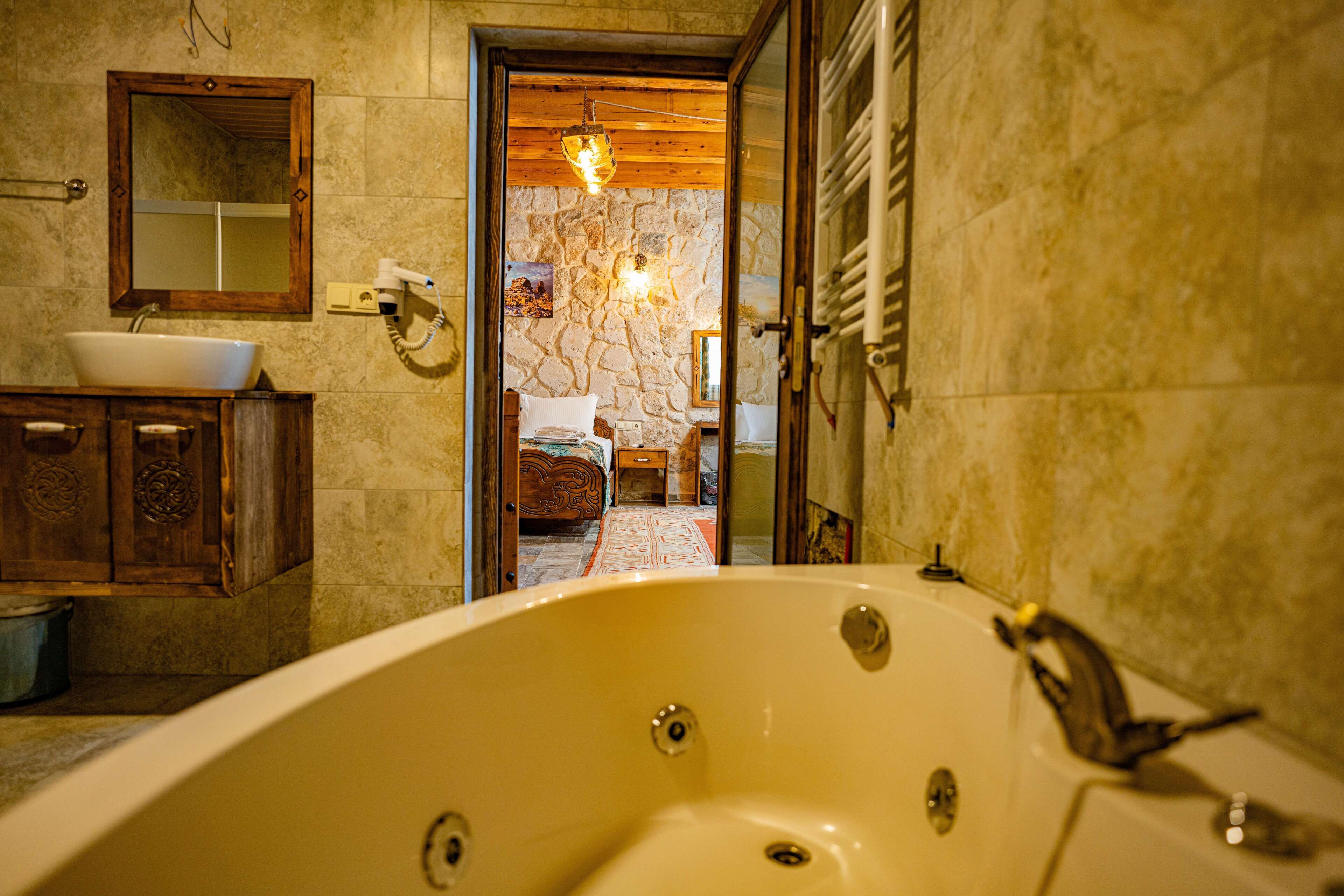A bathroom with a bathtub, a sink, and a mirror.