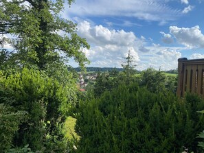 A lush green landscape with a view of a village in the distance. - Double room (apartment 2) - log cabin (Sangerhausen)