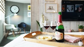 Et spisebord med en rosevinflaske, to glas og en tallerken med mad.