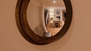 A mirror with a wooden frame reflecting a dining area with a table and chairs. - Malvern House - coastal townhouse located in the heart of Deal (Deal)