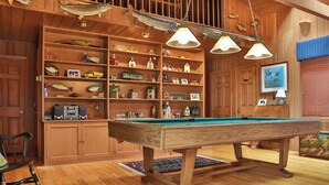 A wooden room with a pool table, shelves with fish and fishing memorabilia, and hanging lights. - Private on Chain O’Lakes! Huge Kitchen, 2 Living Spaces, Large Cousins Room! (Lac Du Flambeau)