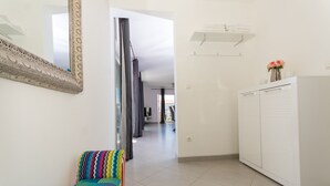 Ein Flur mit einer gemusterten Bank, einem Kleiderschrank und einem Spiegel an der Wand.