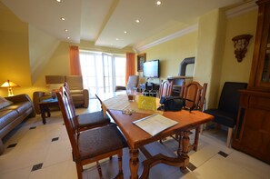 Un comedor con una mesa de madera, sillas, un televisor y una chimenea.