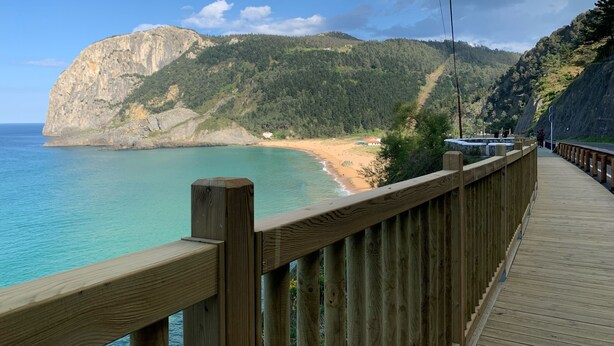 A wooden boardwalk along a coastal area with a view of a beach and a large cliff. - Txoritoki Apartment, Urresti (Gautegiz Arteaga)
