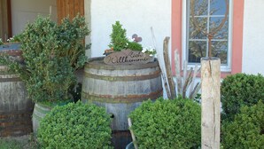 A rustic building with a wooden barrel planter with a sign that reads "Ich Willkommen" and a metal ring decoration. - An oasis for parents, a paradise for children (Tettnang)