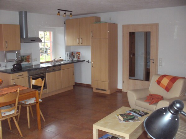 A compact living space with a kitchen, dining area, and a sofa. - An oasis for parents, a paradise for children (Tettnang)