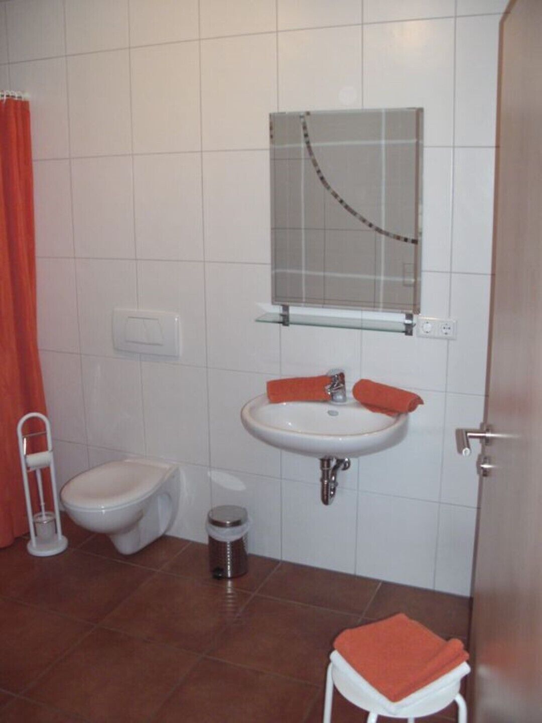Une salle de bain comprenant des toilettes, un bidet, un lavabo et une petite poubelle.