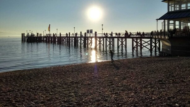A pier extending into calm waters with a clear sky. - An oasis for parents, a paradise for children (Tettnang)