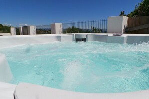 A hot tub with a clear view of the sky and a fence in the background.
