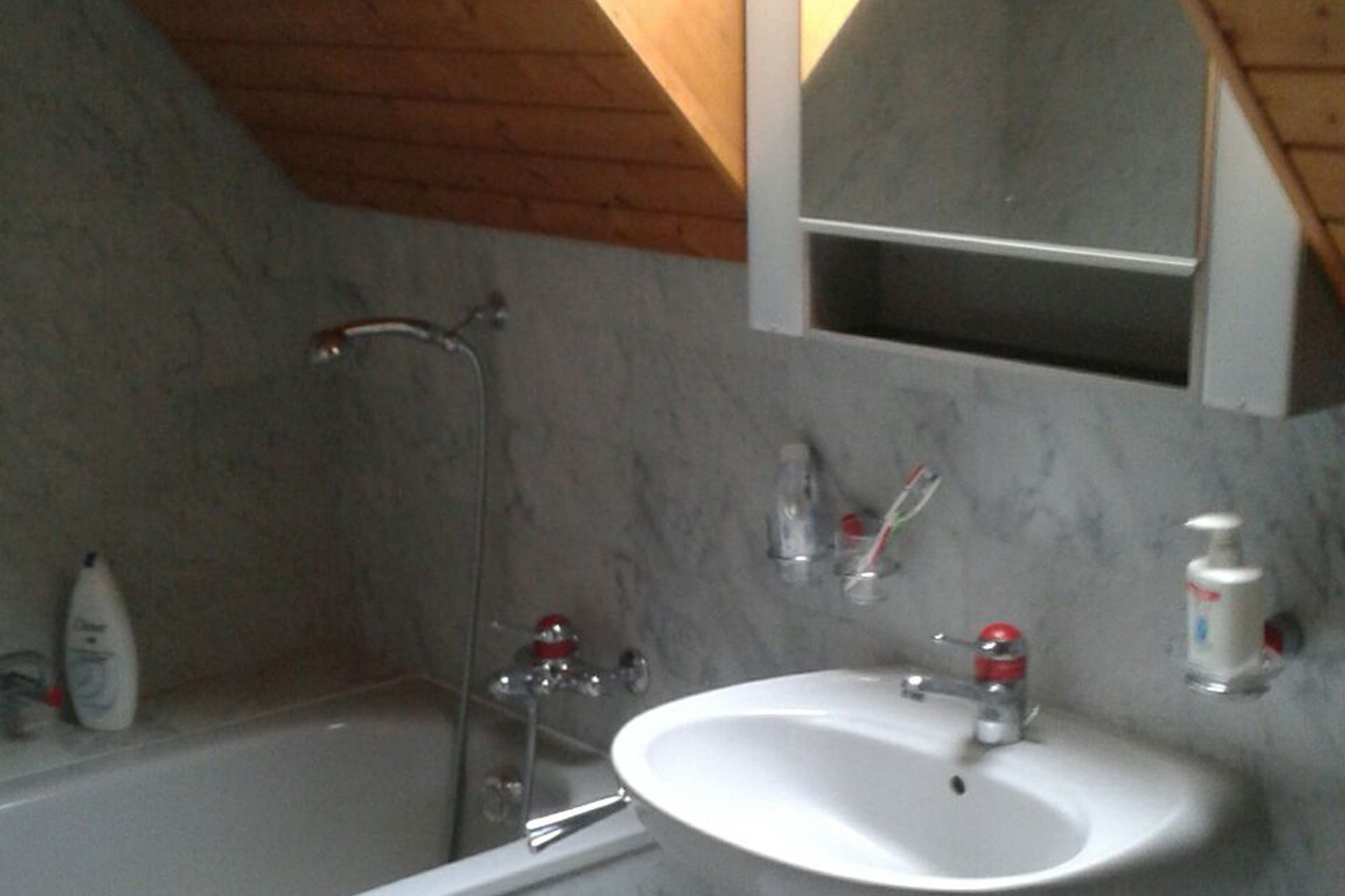 Un baño con bañera, lavamanos y espejo.