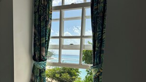 Ein Fenster mit Blick auf den Ozean und einen Strand.