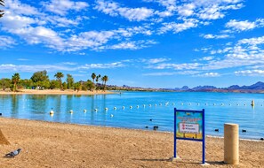 Una playa con un letrero que indica que no se permite vidrio ni alcohol.