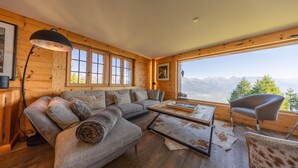 A wooden interior with a sofa, a coffee table, and a chair. - Chalet Riquet - ski-in/out - luxe (Haute-Nendaz)