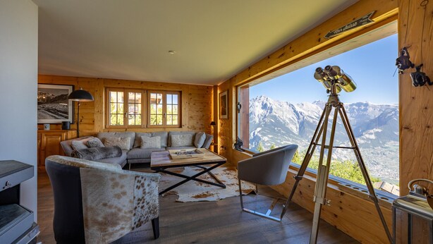 A cozy cabin with a wooden interior, a sofa, a dining table, and a telescope. - Chalet Riquet - ski-in/out - luxe (Haute-Nendaz)