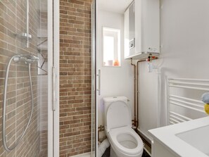 A bathroom with a shower, toilet, and a white sink. - Studio - 2P - Vieux Lyon (Lyon)