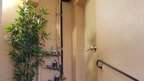 A staircase with a potted plant, a metal bucket, and a blue mat. - Studio - 2P - Vieux Lyon (Lyon)