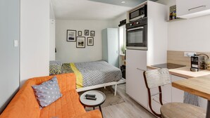 A compact living space with a bed, kitchenette, and a small dining area. - Studio - 2P - Vieux Lyon (Lyon)