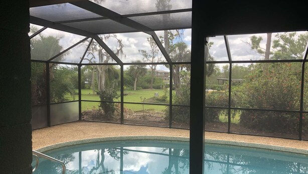 Une piscine couverte avec vue sur une zone verdoyante et des arbres.