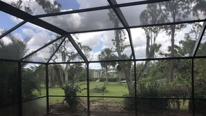 Un espace piscine avec vue sur un jardin aménagé et des arbres.