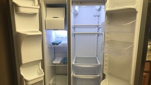 Un réfrigérateur vide, doté de plusieurs étagères et compartiments.