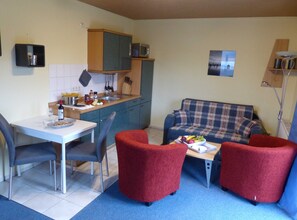 Een knus verblijf met een eethoek, kitchenette en zithoek.