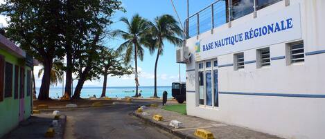 A building with a sign reading "BASE NAUTIQUE RÉGIONALE" and a view of the sea.