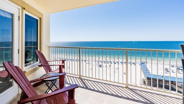 A balcony with red chairs and a view of the beach. - Gulf Shores Beachfront Condo | Sleeps 6 | Gulf-Front Pool & On-Site Dining (Gulf Shores)