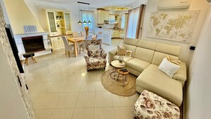 Un salon moderne avec un canapé, des fauteuils, une table basse et une cheminée.