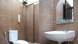 A bathroom with a toilet, shower, and sink.
