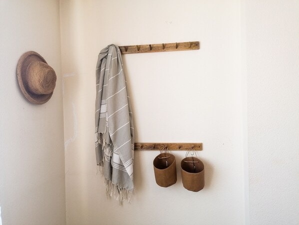 A wall with a wooden coat rack holding a scarf and two shoes. - A13 CONSULADO A 5º 3 (Calpe)