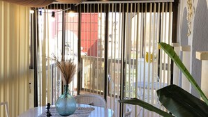 A covered outdoor dining area with a table and chairs, a decorative vase, and a large plant. - A13 CONSULADO A 5º 3 (Calpe)