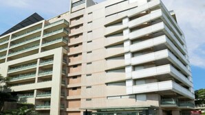 A multi-story hotel with balconies, a glass entrance, and a modern architectural design. - Howard Lake Resort Shihmen Dam (Taoyuan City)
