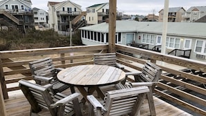 A wooden deck with a round table and six chairs. - Saltaire Cottages8: 2BR Ocean View Steps2 Private Beach Access Screen Porch Pool (Kitty Hawk)