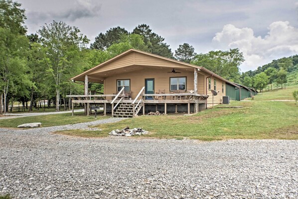 A wooden cabin with a porch, a staircase, and a satellite dish. - The Aviator at Kudzu Cove Cabins Resort (Guntersville)
