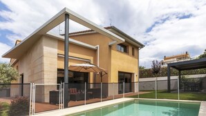 Uma casa moderna com piscina, área de estar externa e varanda coberta.