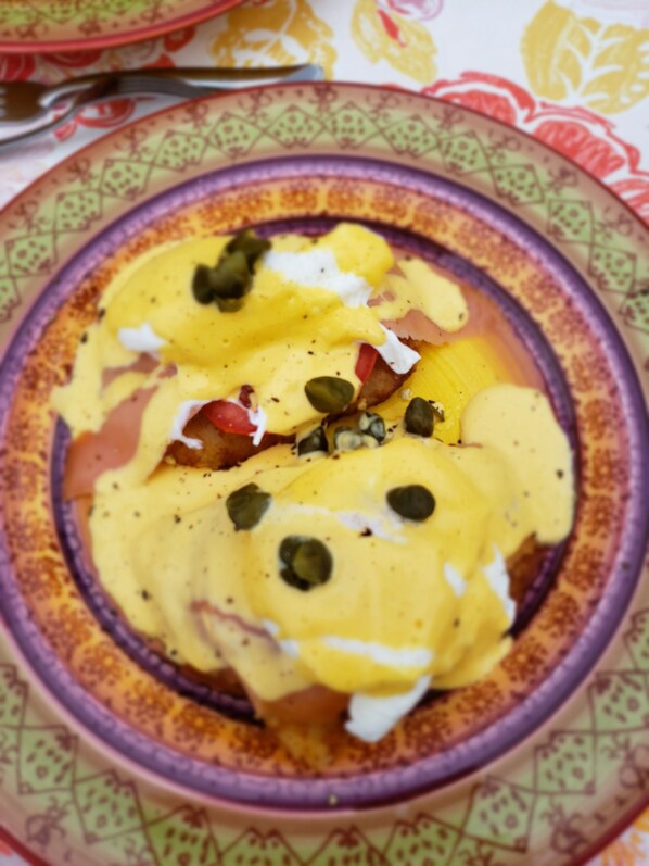 A plate with a dish topped with yellow sauce, seeds, and a white topping. - Pink Palace Panama (Punta Chame)