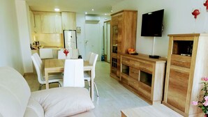 Un soggiorno moderno con un divano, un tavolino in legno e un'area pranzo con tavolo e sedie.
