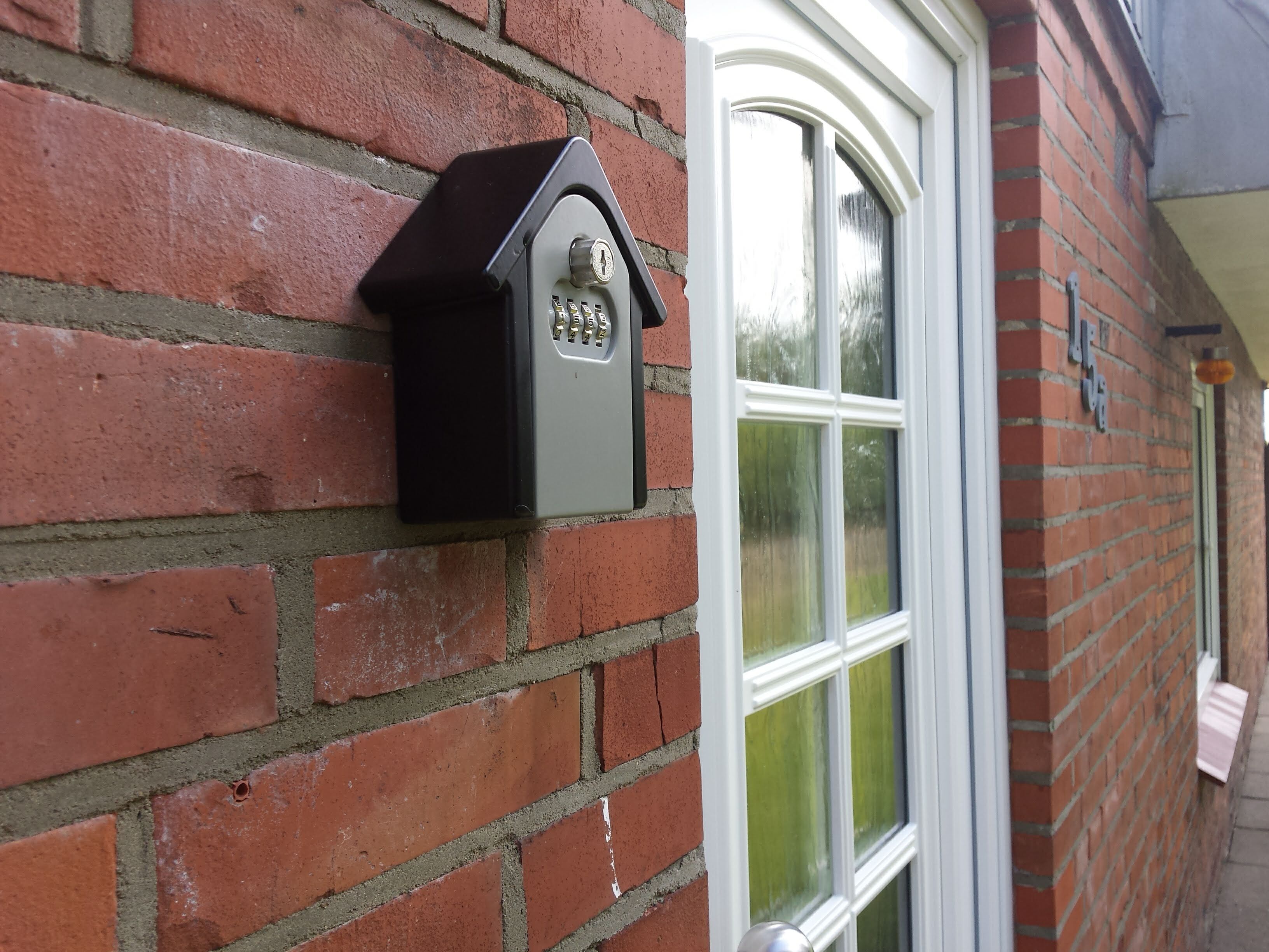 Eine Ziegelwand mit Briefkasten und Fenster.