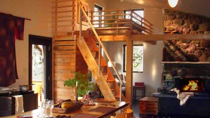 Un comedor de madera con una escalera alta de madera, una chimenea y vistas al exterior.