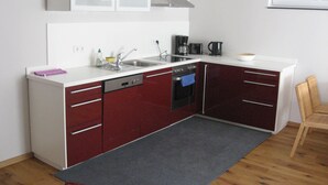 A compact kitchen with a sink, stove, and cabinets.