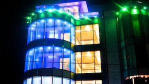 A building with multiple illuminated windows and a curved facade. - Leisure Inn (New Amsterdam)