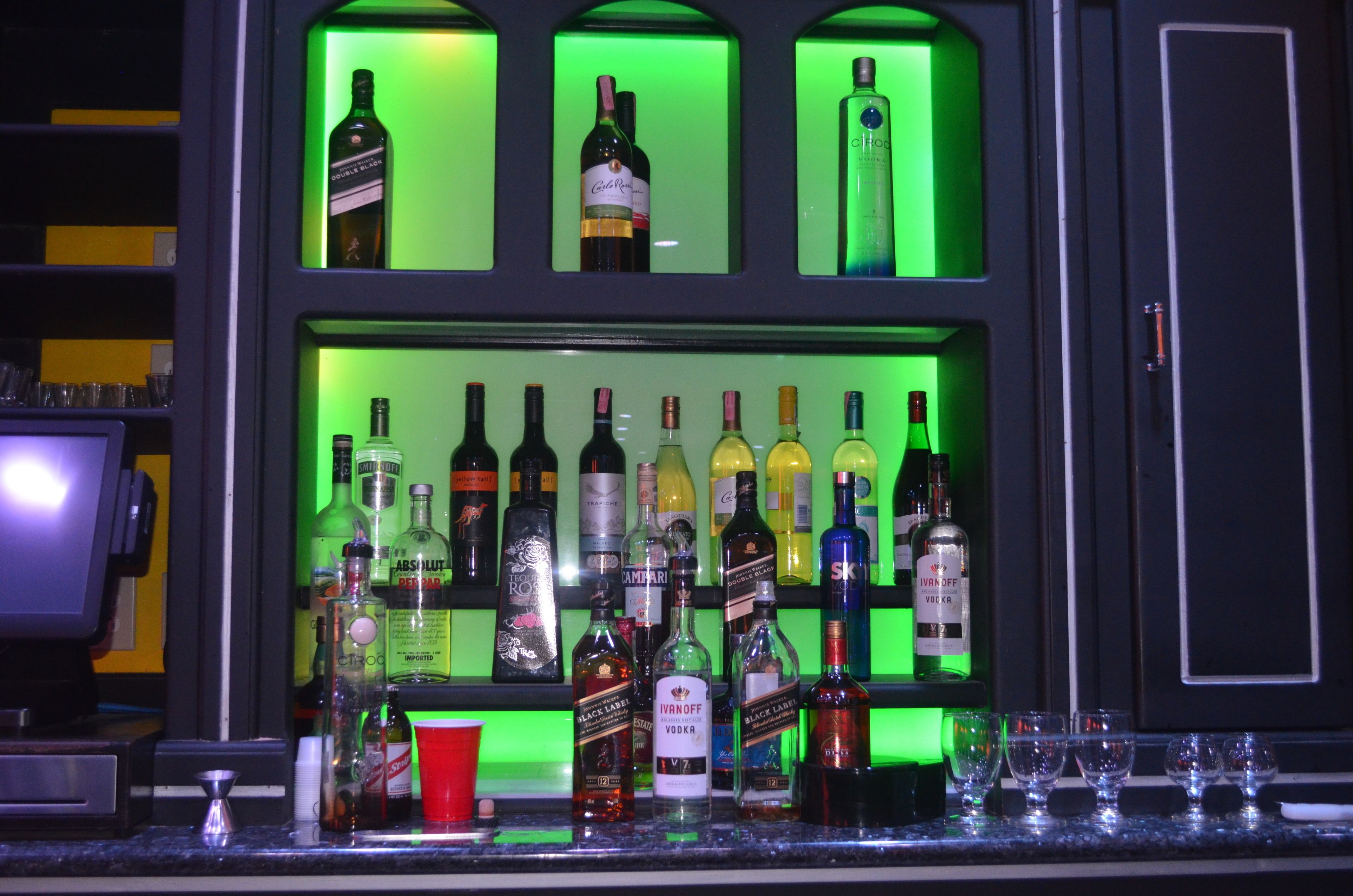 A bar with various bottles of alcohol and glasses.